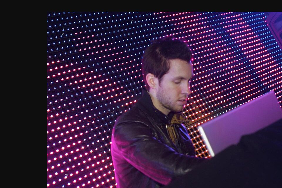 Archival 2009 photograph of Calvin Harris performing behind a DJ setup; this is not a 2027 tour image