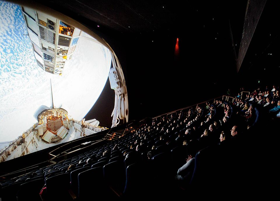 Archival NASA photograph of an IMAX audience watching a space documentary at the Smithsonian in 2012; illustrative of a large-screen release, not a scene from Narnia.