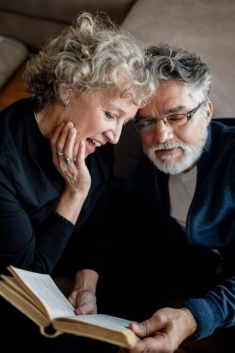 Illustrative licensed photograph of an older couple reading a book at home; the people are not identified as Pension Credit claimants or leaflet recipients
